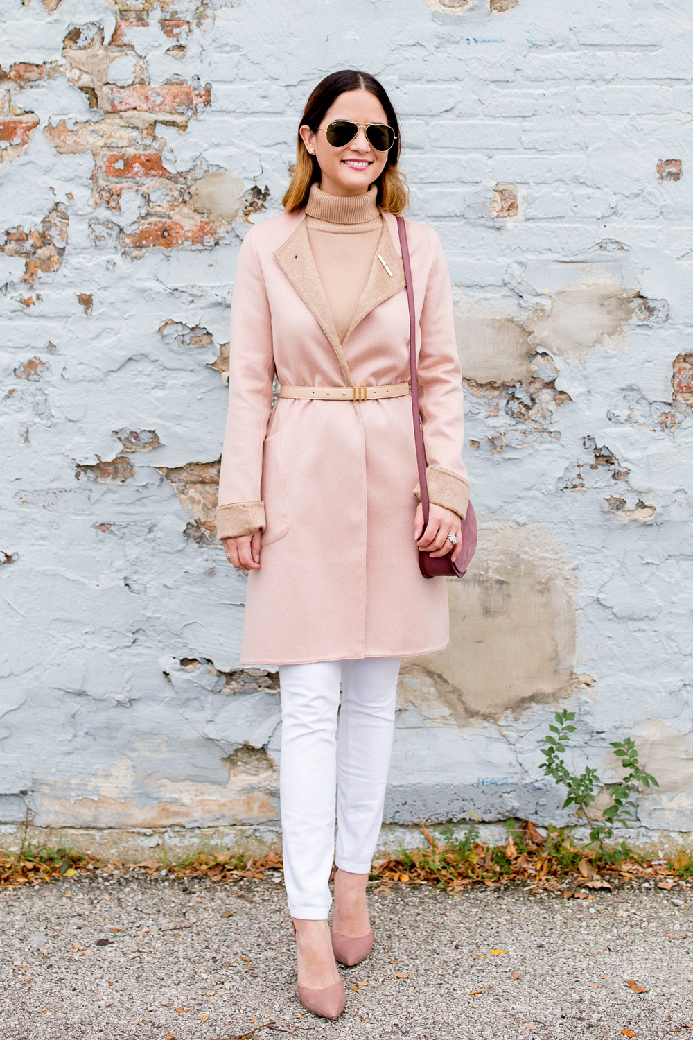 Jennifer lake in a Cuyana pink cashmere coat, belt, and saddle bag