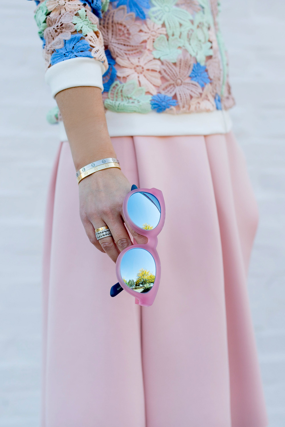 Jennifer Lake Style Charade in a Nordstrom pastel lace bomber jacket, pink skirt, and pink Packed Party Toms sunglasses