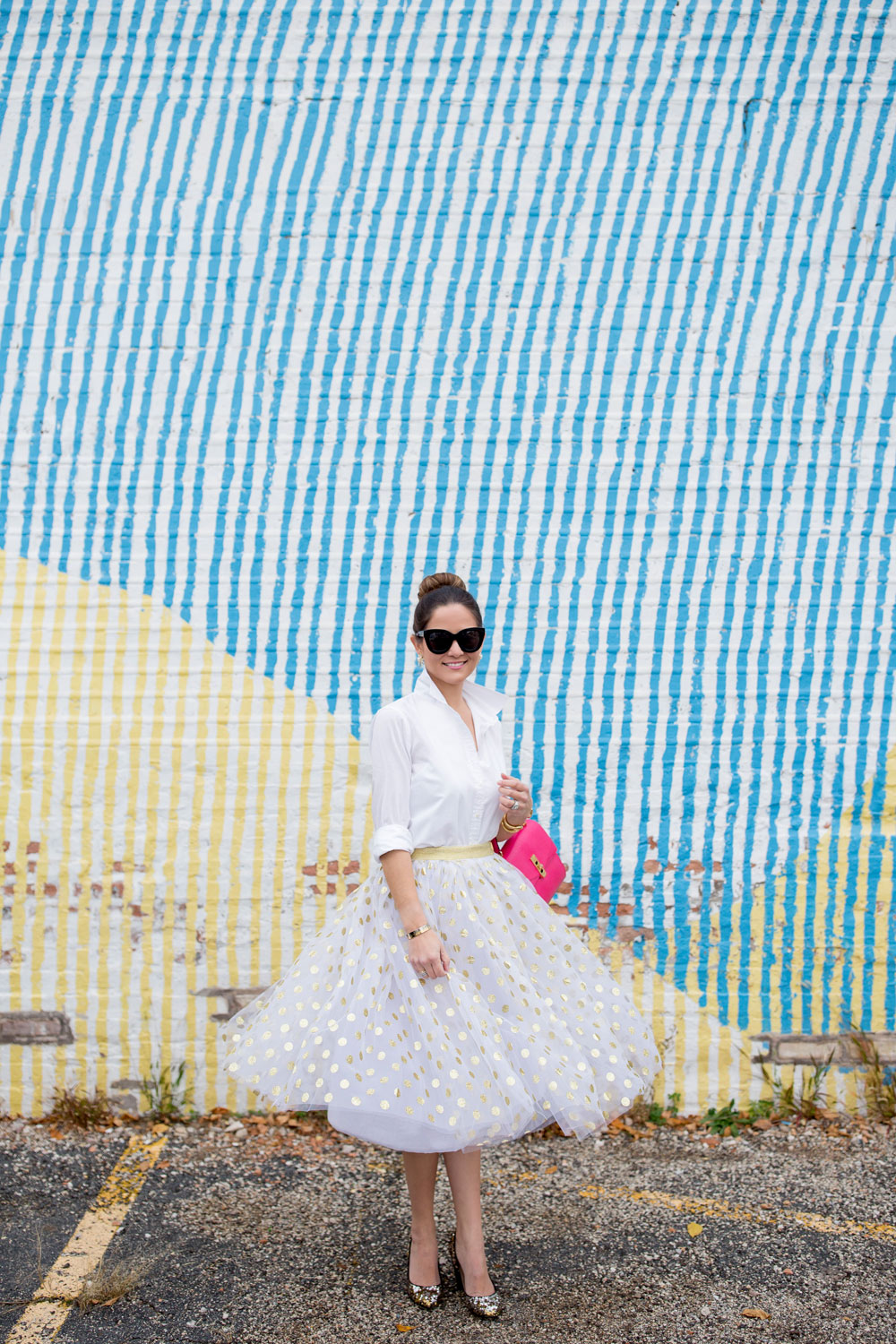 Jennifer Lake Style Charade twirling in a T and J Designs gold glitter polka dot midi skirt, Henri Bendel Uptown Satchel and J Crew sequin pumps at a colorful Chicago mural